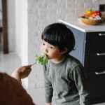 young boy eating some vegetables getting nutrients the healthy way