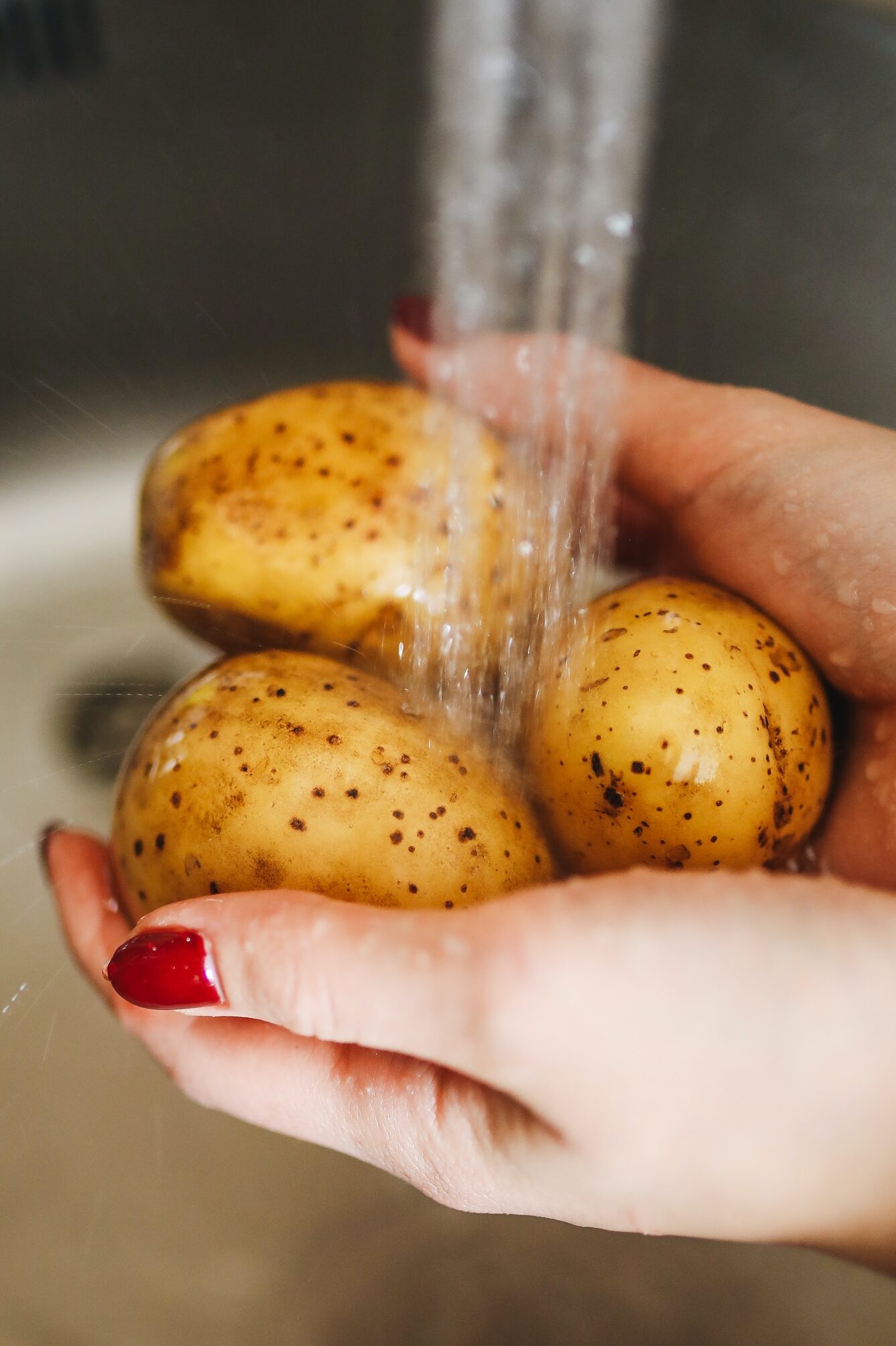 Photo Of Person Holding and washing Potatoes