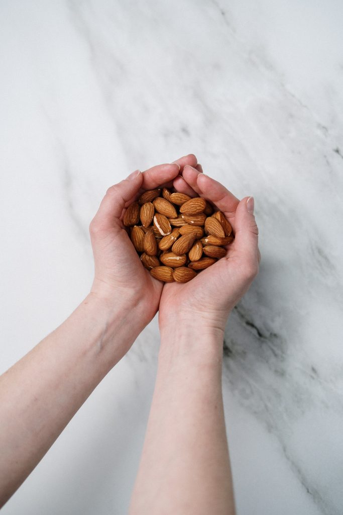 Hand holding a handful of almonds as a healthy snack option