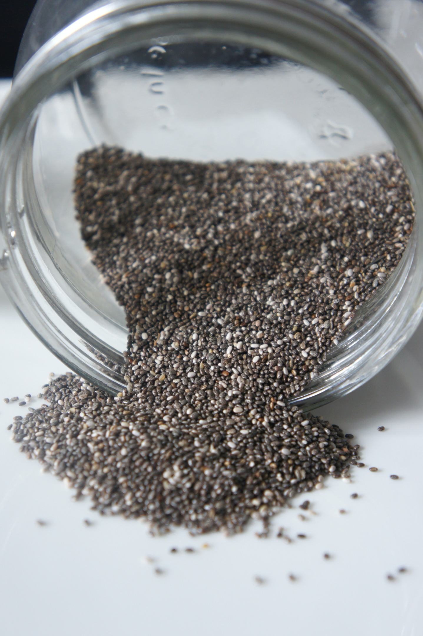 Chia seeds spilling out of a glass pot, highlighting a powerful constipation relief food and natural fiber source for digestive health